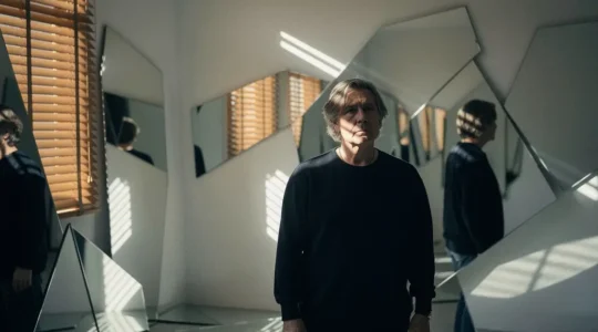 Personne contemplant son reflet multiple dans des miroirs fragmentés, symbolisant la quête d'identité au milieu de vie