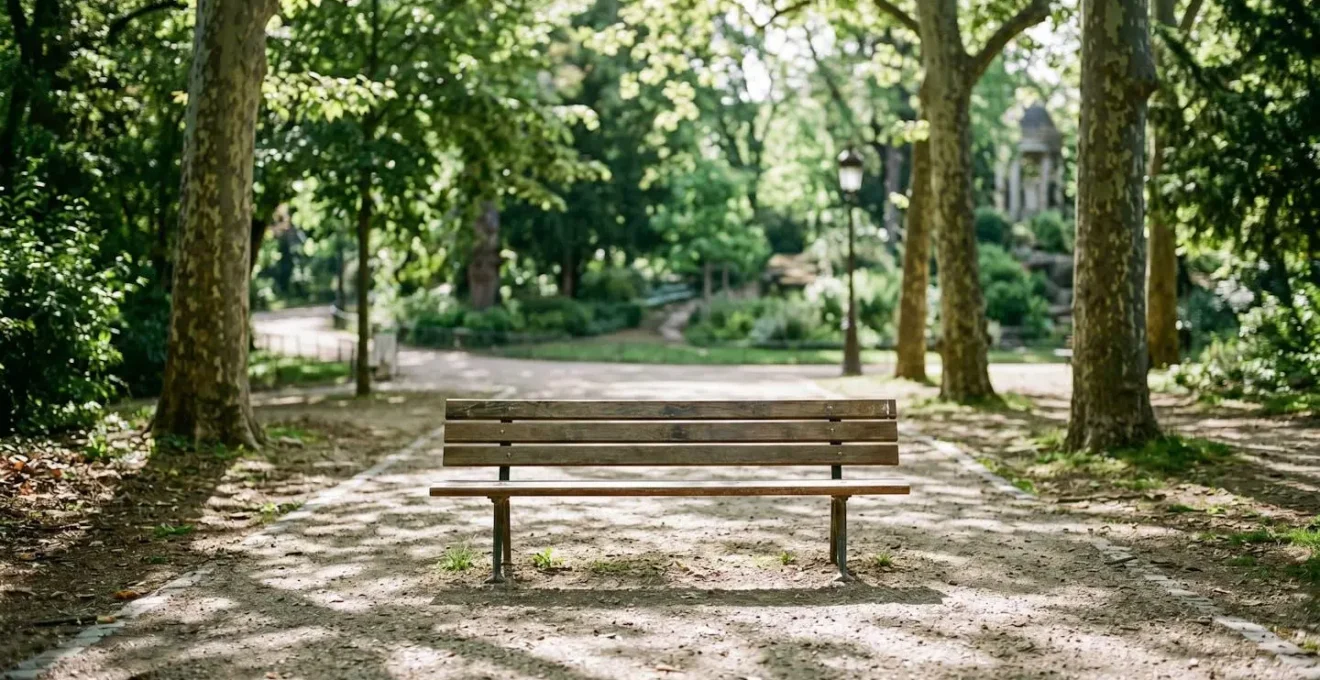 Banc de parc urbain vide dans un espace vert calme, lumière filtrée par les arbres, atmosphère paisible